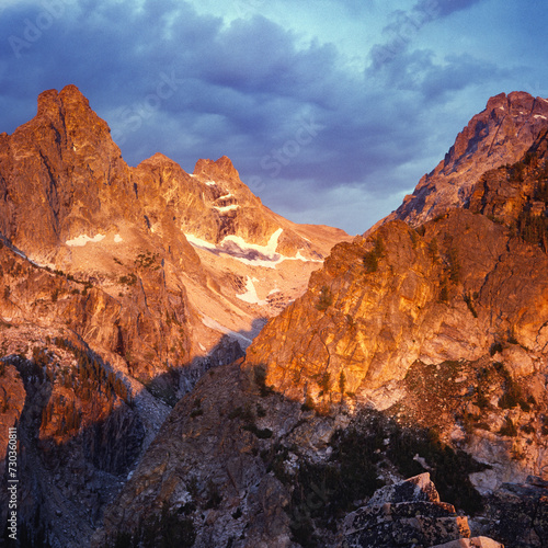 From a small peak above Amphitheater Lake, Nez Perce (left) and Middle Teton (right) bask in summer alpenglow at sunrise. Square format photo