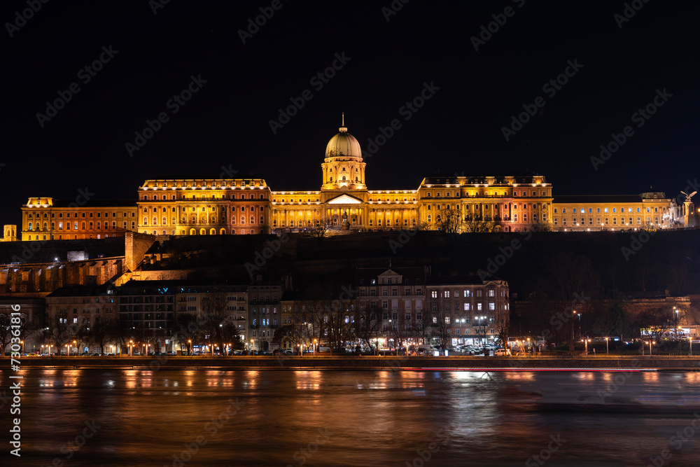 Obraz premium The historical Buda castle district above the Danube river illuminated by lights at night in Budapest