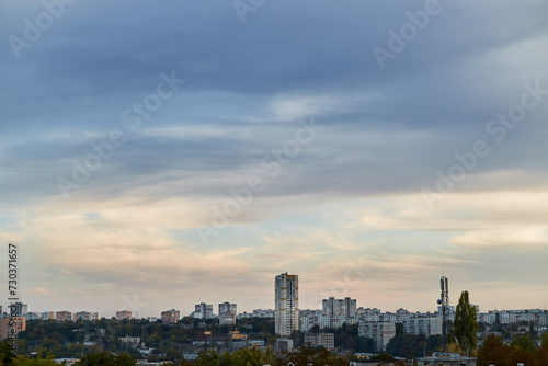 Feather clouds in the evening light on the blue sky over the city. © Александр Ланевский