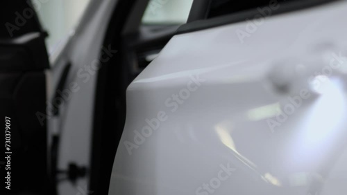 Mans hand opens and closes door of white modern car photo