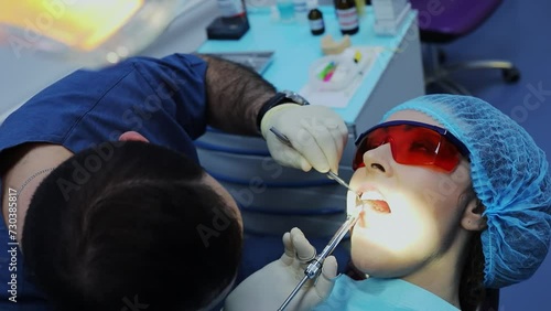  Dentist makes anesthetic injection in gum of woman  before tooth healing. Slow motion photo