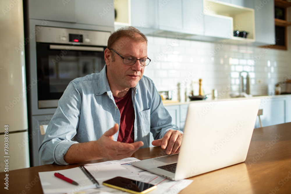 Stressed man going over bills at home Stressed man going over bills at home