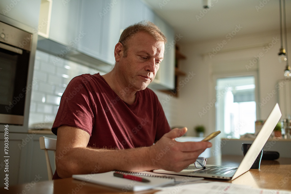 Stressed man going over bills at home Stressed man going over bills at home