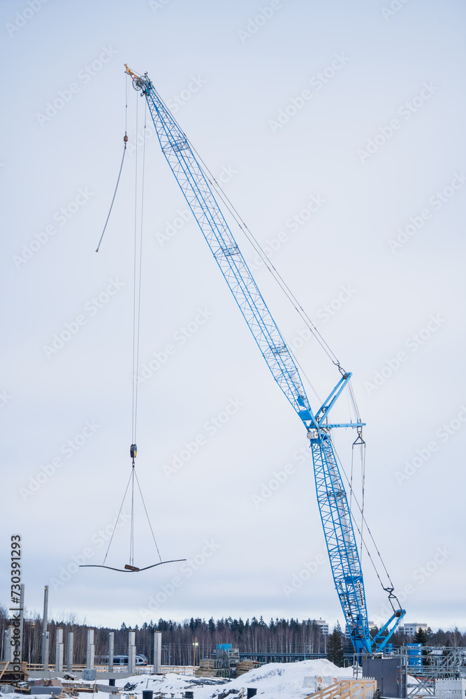 Blue construction crane lifting cement blocs