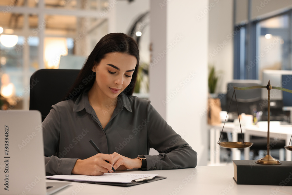 Portrait of confident lawyer working at table in office Portrait of confident lawyer working at table in office