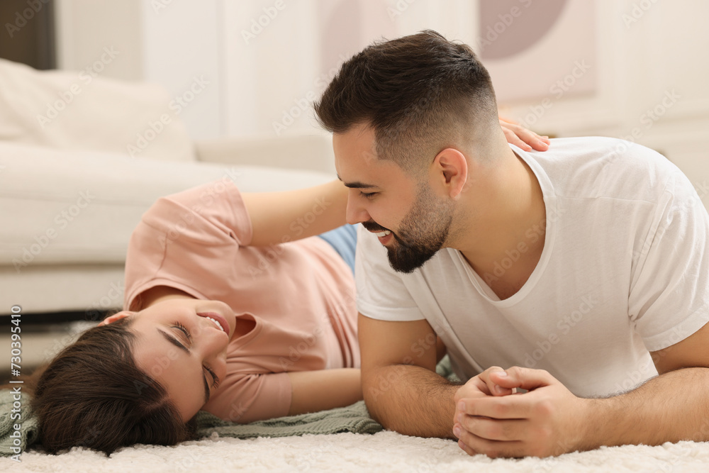 Affectionate young couple spending time together on soft carpet at home Affectionate young couple spending time together on soft carpet at home