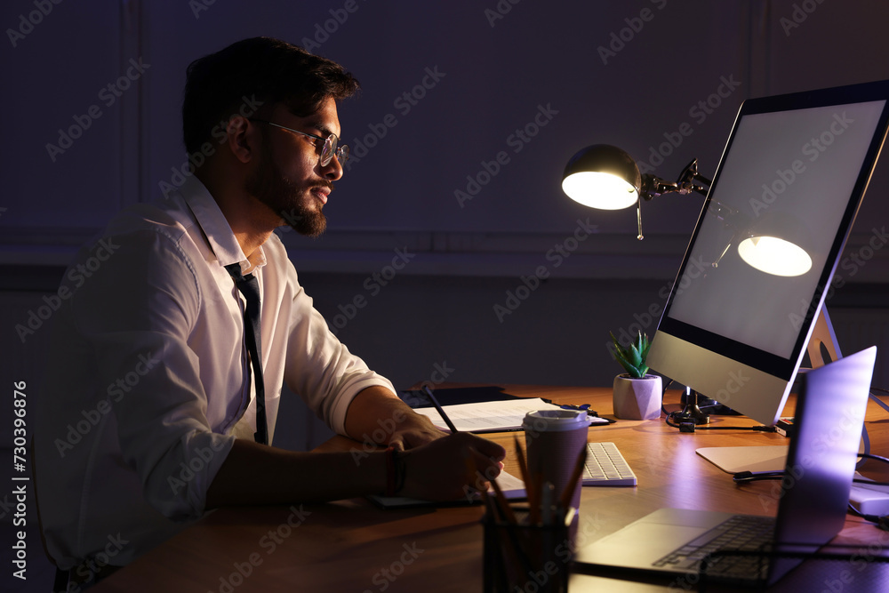 Tired young man working late in office Tired young man working late in office