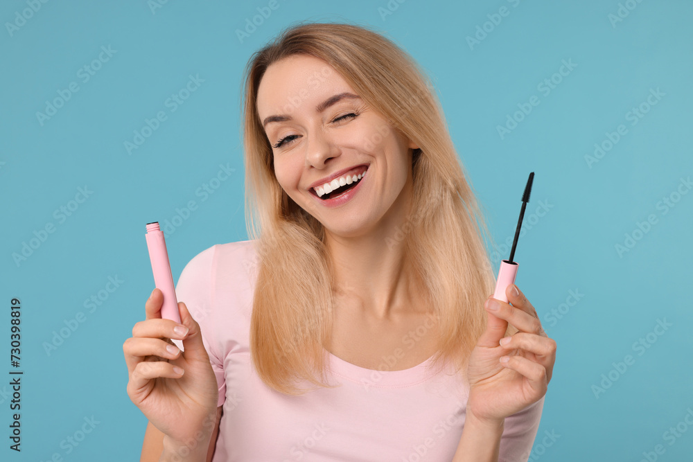 Beautiful woman with mascara on light blue background Beautiful woman with mascara on light blue background
