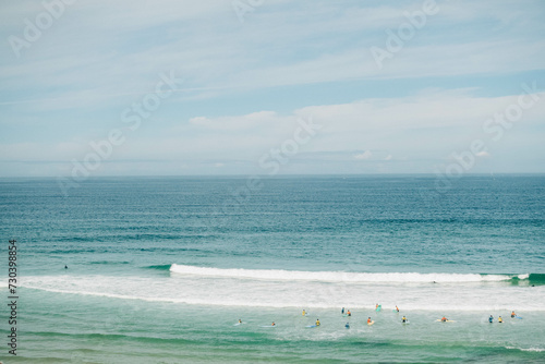 Serene beach scene with distant surfers and swimmers