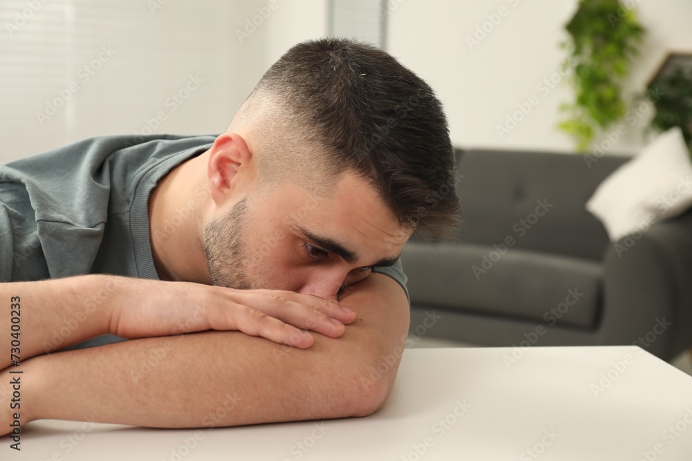 Sad man at white table indoors. Space for text Sad man at white table indoors. Space for text
