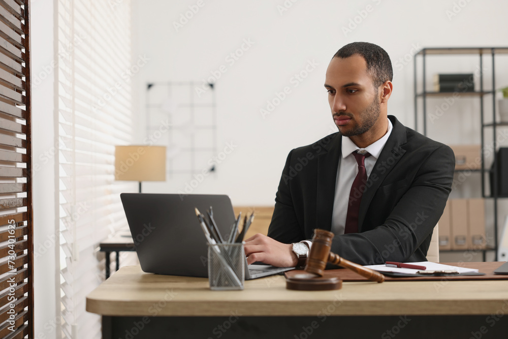 Serious lawyer working with laptop at table in office Serious lawyer working with laptop at table in office