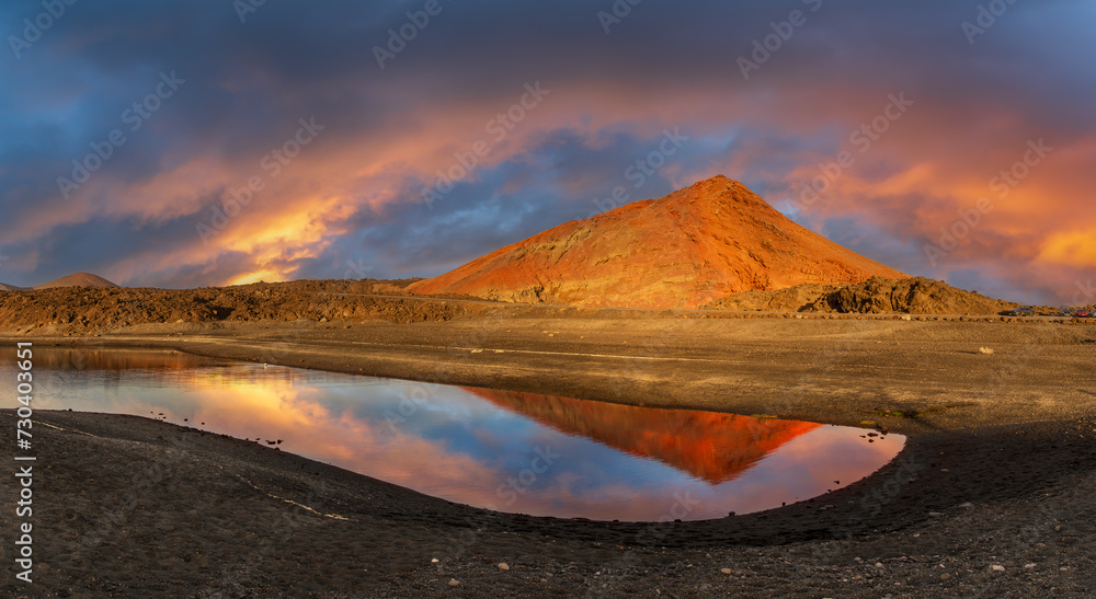 Captivating sunset at Los Hervideros, Lanzarote, reflecting on tranquil waters with the fiery glow of volcanic landscapes - ideal for stunning visuals