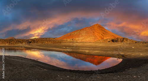 Obraz na płótnie Captivating sunset at Los Hervideros, Lanzarote, reflecting on tranquil waters with the fiery glow of volcanic landscapes - ideal for stunning visuals w salonie