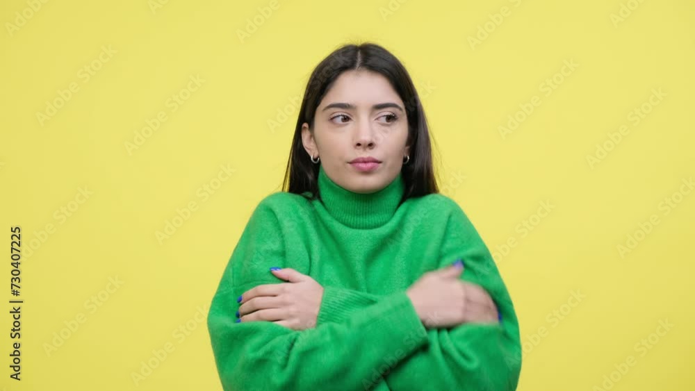 Frozen young Caucasian woman rubbing hands, feeling the cold, cowardly from the cold, trying to warming standing over yellow background. Frozen young Caucasian woman rubbing hands, feeling the cold, cowardly from the cold, trying to warming standing over yellow background.