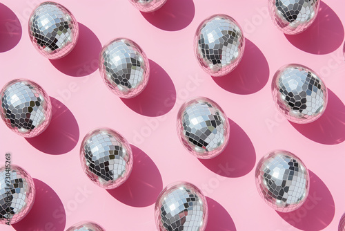 Modern pattern made of metal disco ball eggs on a pastel pink background. Easter party. Minimal christian holiday concept.
