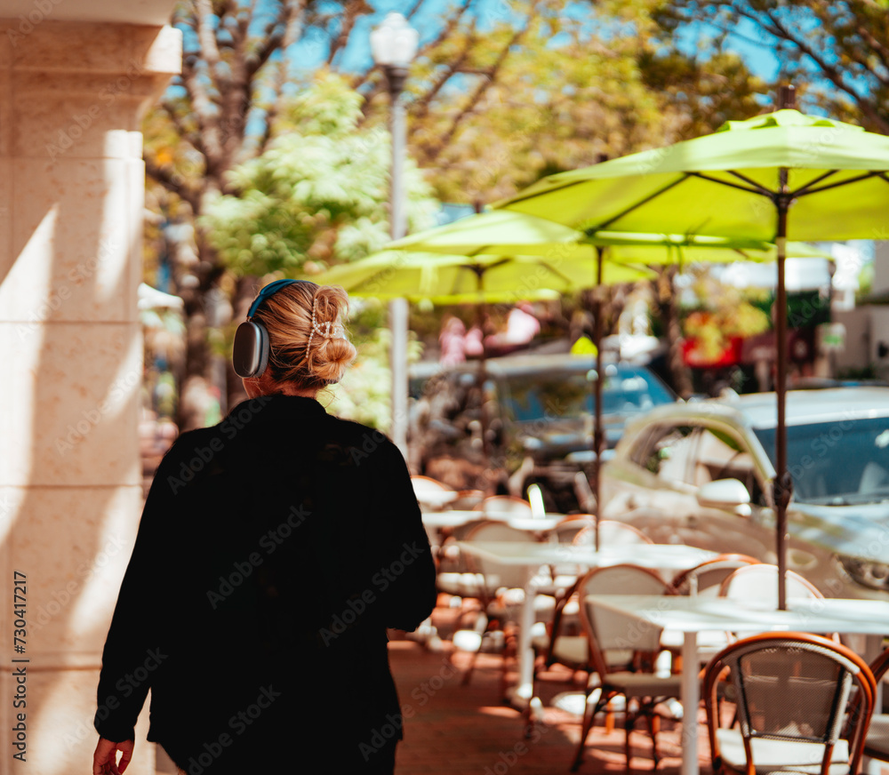 woman walking coconut grove miami listen music 