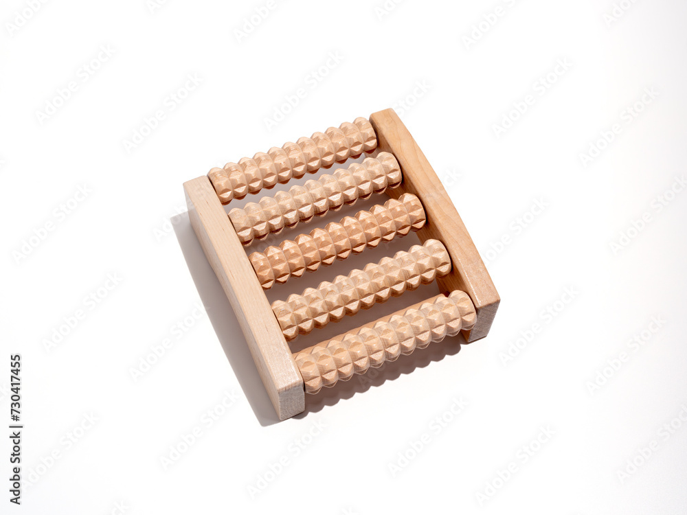 Wooden foot massager on a white background. Wooden massager close-up. Wooden foot massager on a white background. Wooden massager close-up.