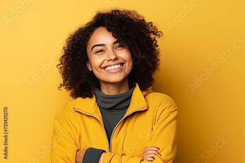 Portrait of a beautiful young african american woman smiling over yellow background