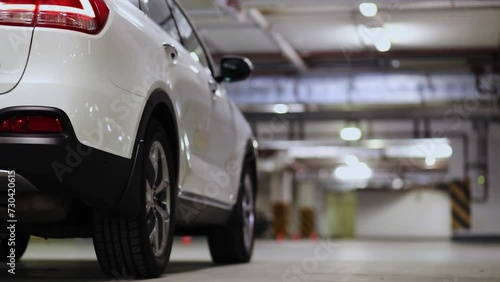 Rear wheel of white car which stand on underground parking