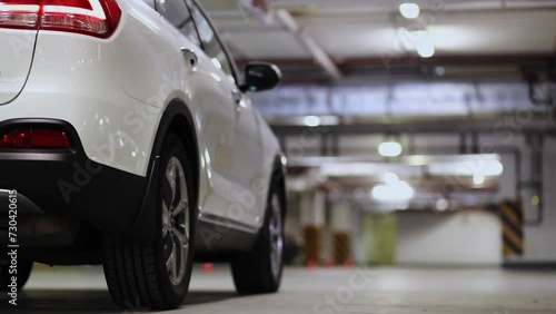 Rear wheel of white car which stand on underground parking photo