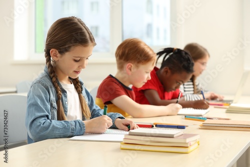 Cute children studying in classroom at school