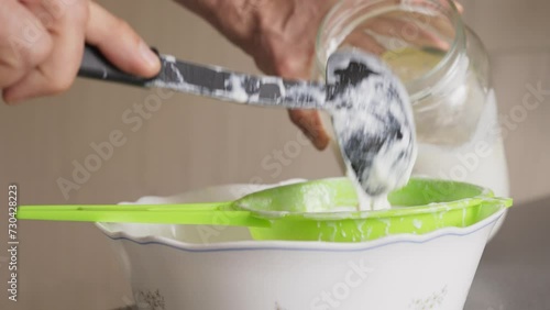 Filtering homemade Kefir mushrooms real time 60 fps, healthy foods for breakfast filtered by strong hands with soft natural lighting