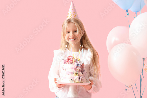 Cute little girl in party hat with Birthday cake and balloons on pink background