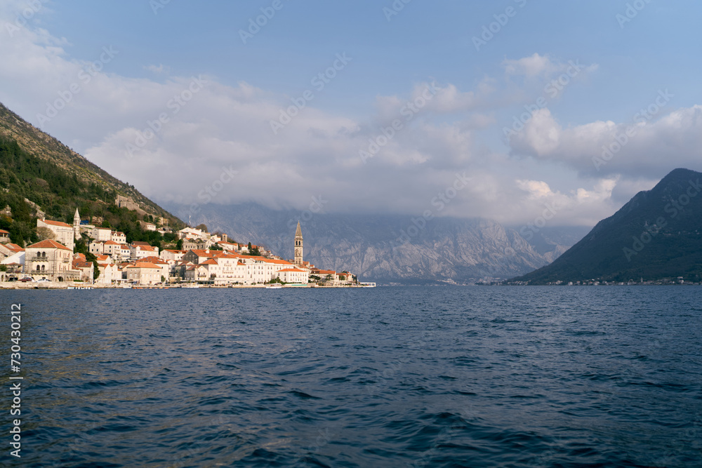 View from the sea to the ancient town of Perast at the foot of a high mountain range. Montenegro