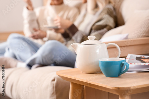 Teapot with cup on table of...