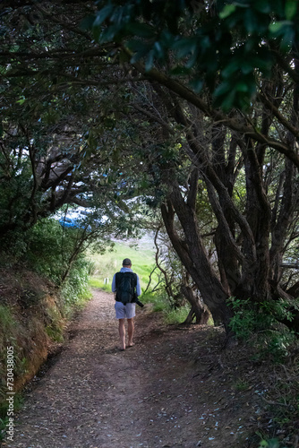 Man walking along a track at Matauri Bay, Northland, New Zealand. © Zenstratus