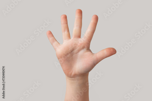 Child hand showing five fingers isolated on grey background, close-up © somemeans