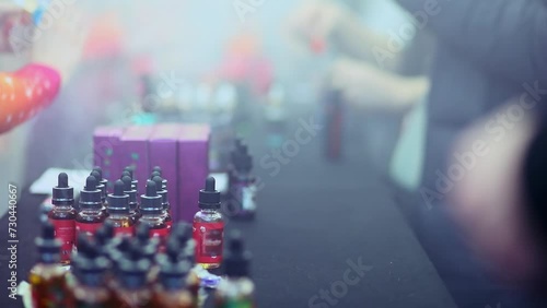 Bottles with different tastes solutions for vape smoker during exhibition photo