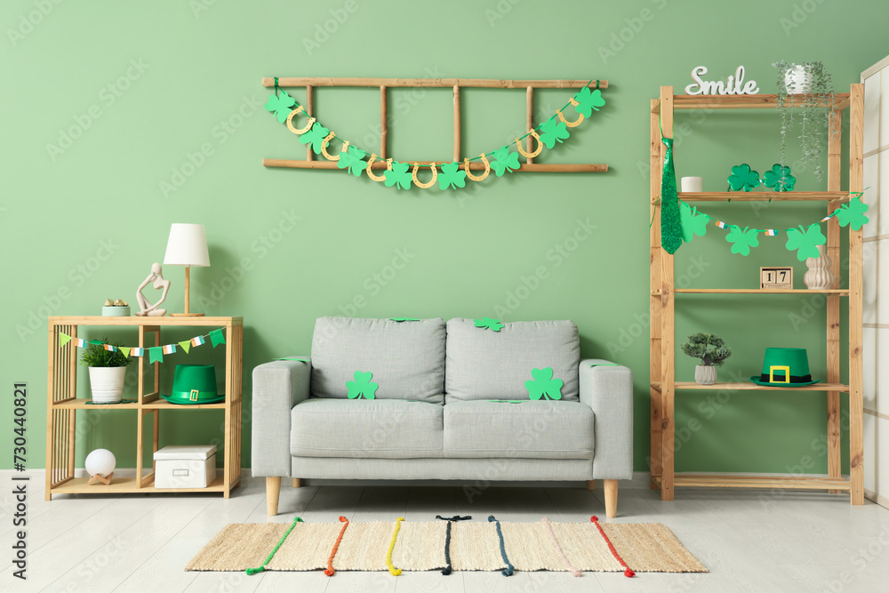 Interior of festive living room with grey sofa and decorations for St. Patrick's Day celebration - obrazy, fototapety, plakaty 