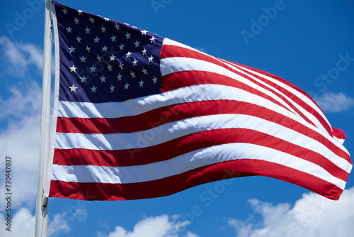 American Flag Waving in the Wind with Blue Sky, Clouds