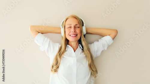 Wallpaper Mural Portrait of happy relaxed middle aged woman listening to music with headphones Torontodigital.ca