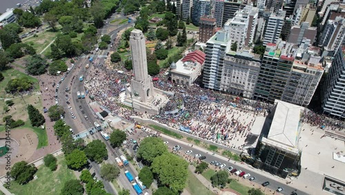 Monumento a la bandera argentina con gente manifestandose photo
