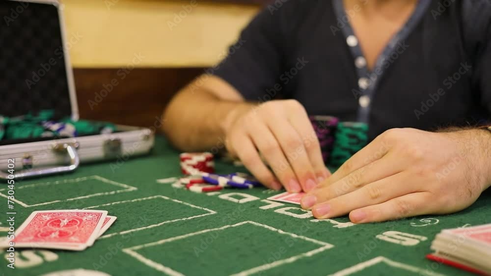 Man looks and hides his cards during poker game on table with chips Man looks and hides his cards during poker game on table with chips