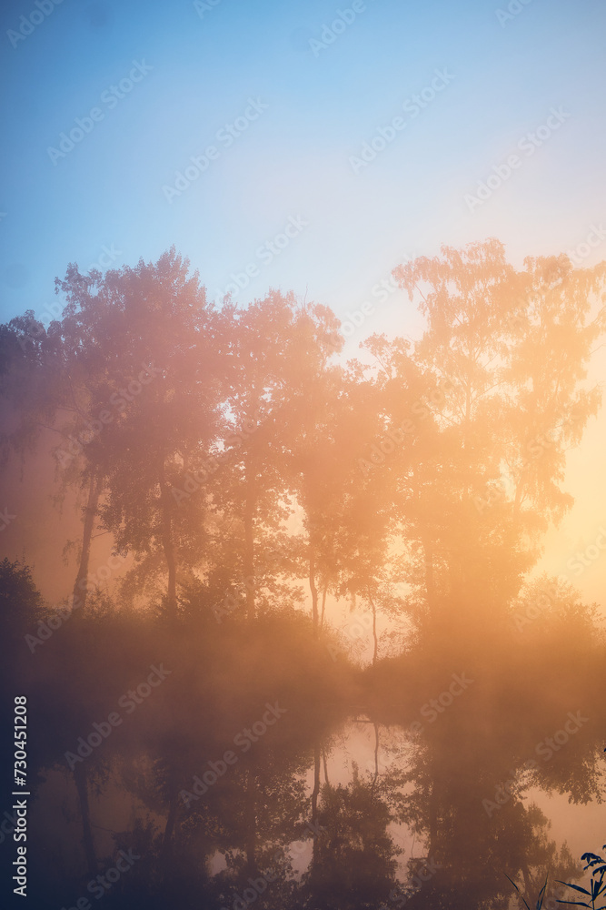 Fototapeta premium Sun rising over foggy lake. High quality photo
