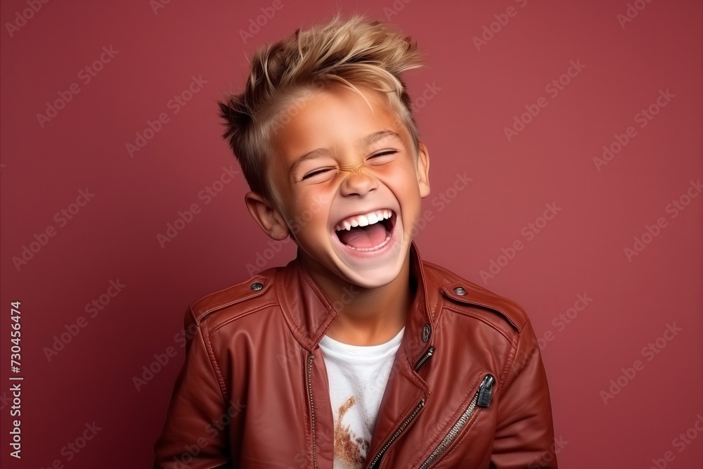 Portrait of a cute little boy in a brown leather jacket over dark background. Portrait of a cute little boy in a brown leather jacket over dark background.