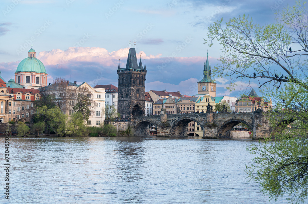 Prague, Czech Republic skyline with historic Charles Bridge and Vltava river on sunny day.
