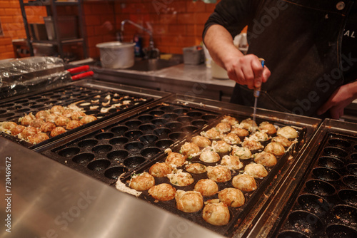 Selective focus at Takoyaki, ball-shaped Japanese snack made of a wheat flour-based batter and cooked in a special molded pan.