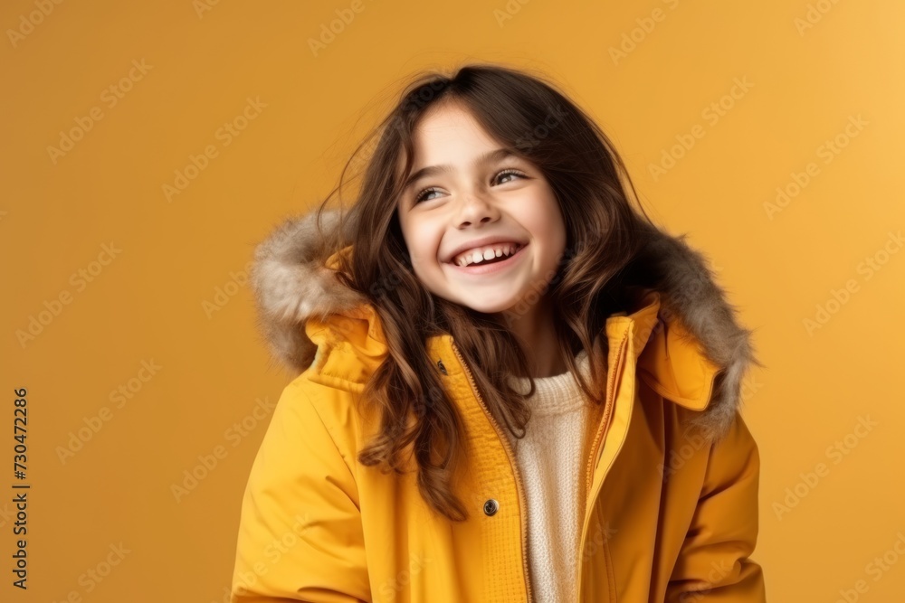 Portrait of a smiling little girl in a yellow jacket on a yellow background Portrait of a smiling little girl in a yellow jacket on a yellow background