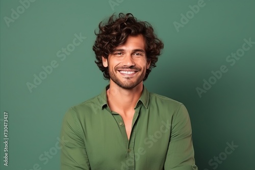 Portrait of a handsome man smiling at the camera over green background