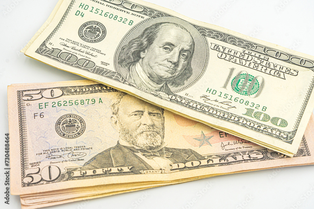 Close up of different dollar bills. Isolated on a white background. 100 and 50 dollar bundles up close on a white background