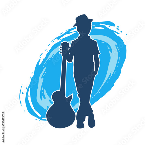 Silhouette of a young kid in pose with an acoustic guitar. Silhouette of a young musician in pose with acoustic guitar musical instrument.