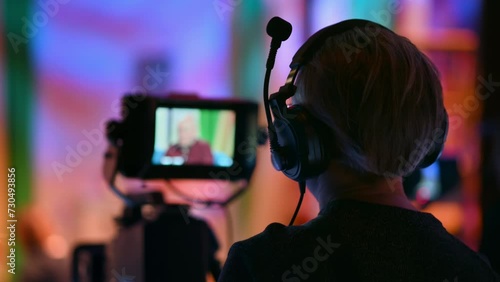 Cameraman filming a television talk show on a professional camera. Video production backstage in a dark studio