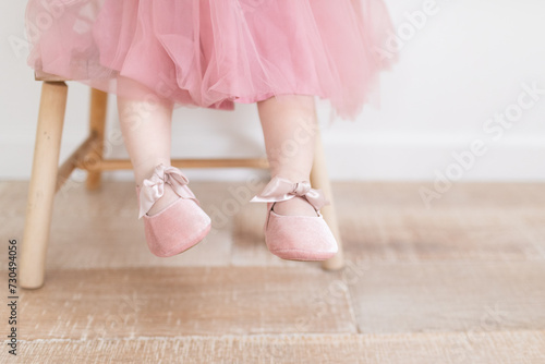 Close up of baby feet with pink ballet slippers and a pink tutu