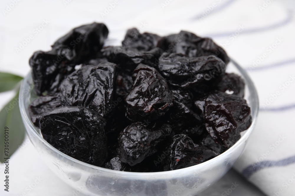 Sweet dried prunes in bowl on light table, closeup Sweet dried prunes in bowl on light table, closeup