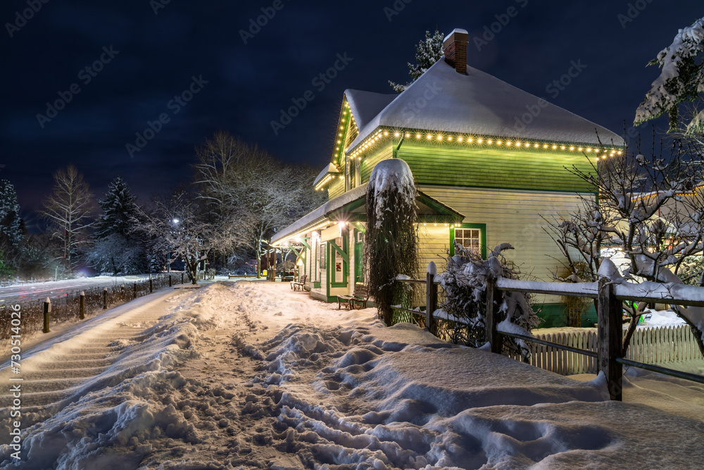 Old heritage train station during Christmas time, with winter decorations. Outdoor Christmas landscape in the snow. Night shot HDR landscape. Dreamy and utterly silent vibe.