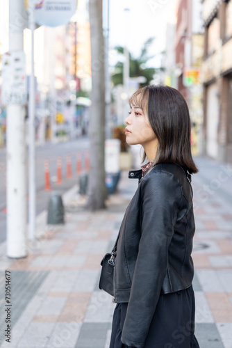 沖縄県那覇市の国際通り周辺を寒い冬に歩く若い２０代の沖縄県出身女性 A young woman from Okinawa Prefecture in her 20s walking around Kokusai-dori Street in Naha City, Okinawa Prefecture in a cold winter photo